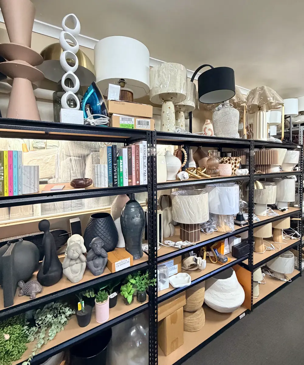 Shelves of lamps, vases, books and styling accessories in the Staged Right Co factory.
