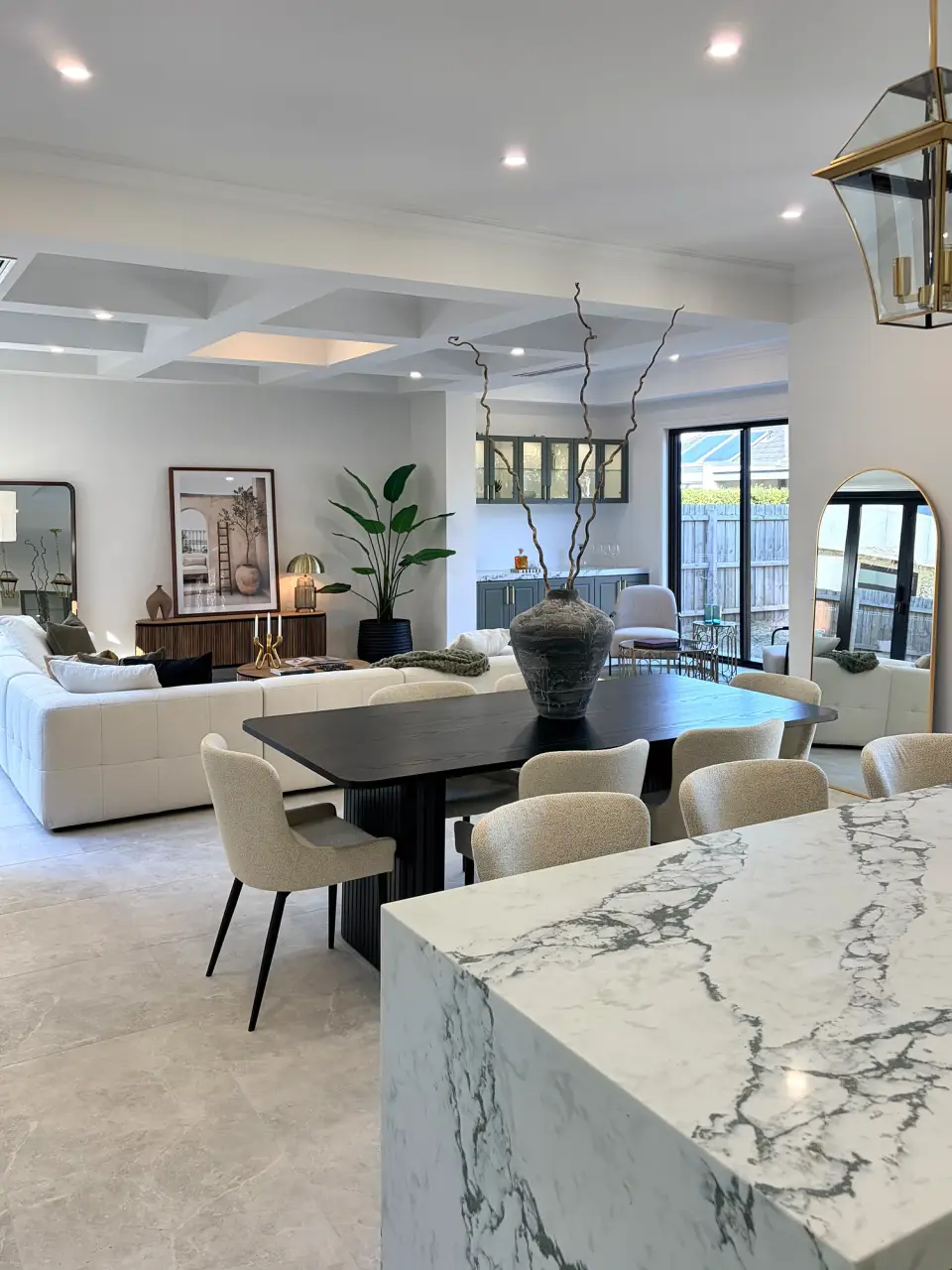 Marble waterfall kitchen bench looking across the dining table to the living area.