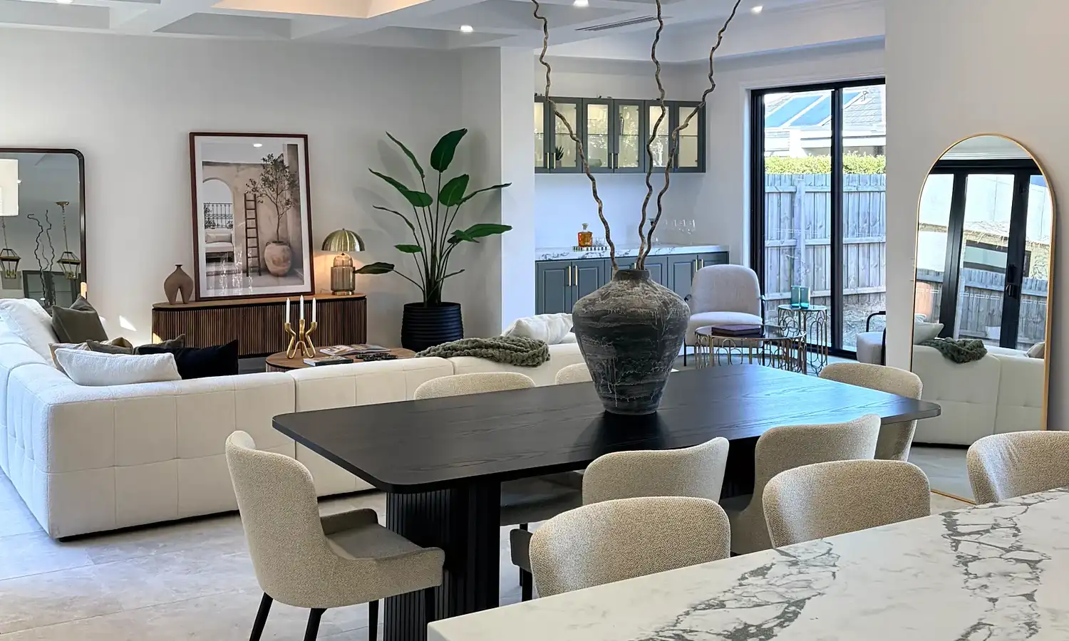 Marble waterfall kitchen bench looking across the dining table to the living area.