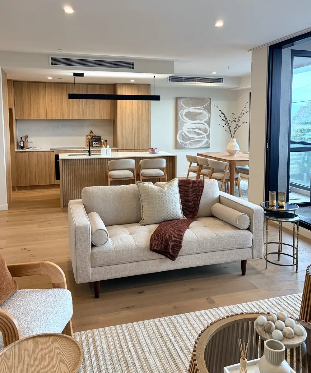 Second living area with a cream sofa and curved armchairs, open to the kitchen.