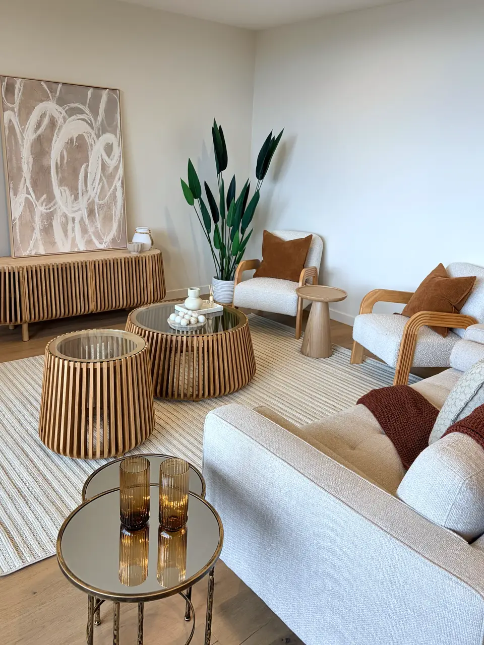 Cream armchairs, fluted timber side tables and abstract artwork in the second living area.