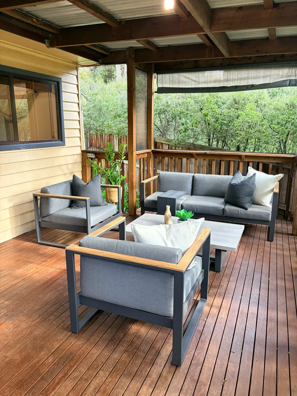 Covered deck with a grey outdoor lounge setting.