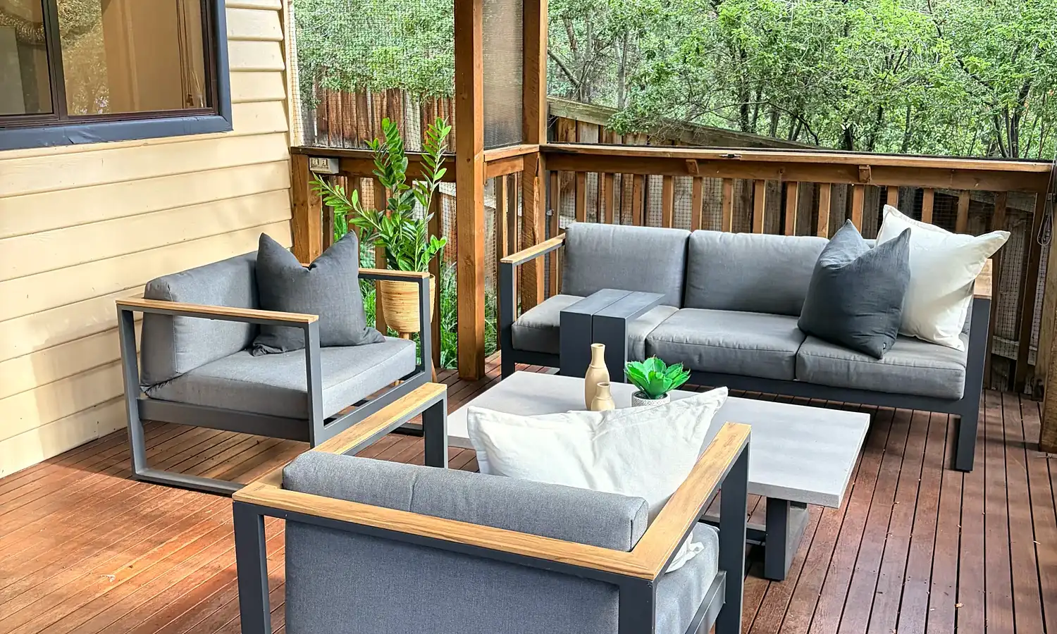 Covered deck with a grey outdoor lounge setting.